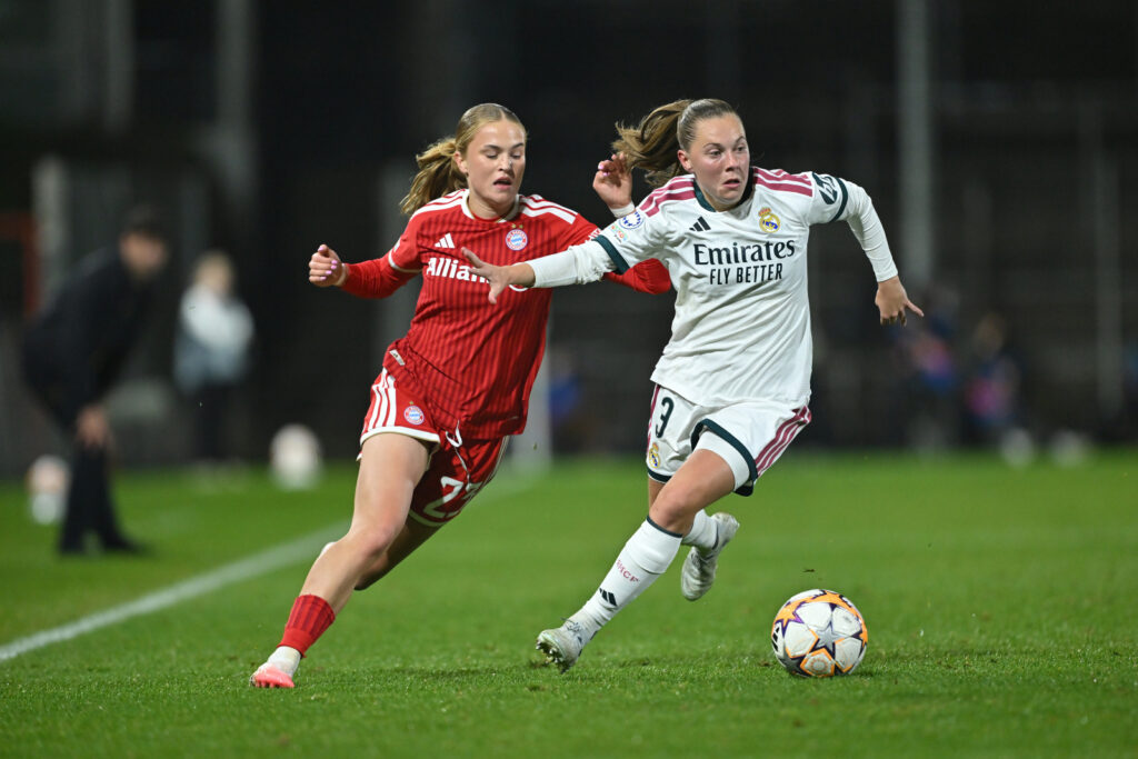 UNTERHACHING, GERMANY - OCTOBER 28: Janou Levels of Real Madrid CF runs with the ball under pressure from Sophie Proost of FC Bayern Munchen during the UEFA Women's Champions League 2026/27 League Phase MD3 match between FC Bayern München and Real Madrid C.F. at Stadion Am Sportpark on October 28, 2026 in Unterhaching, Germany. (Photo by Sebastian Widmann - UEFA/UEFA via Getty Images)